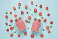 Strawberry milkshake in two glass mason jars on pastel blue background. Royalty Free Stock Photo