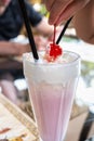 Strawberry milkshake with whipped cream and cherry on top, retro dessert topping