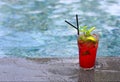 Strawberry Mojito cocktail at the edge of a resort pool. Concept of luxury vacation Royalty Free Stock Photo