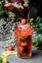 Strawberry Mojito. Cold summer mojito cocktail with strawberries, mint, lemon and ice in a glass on a table. on a dark background Royalty Free Stock Photo