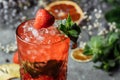 Strawberry Mojito. Cold summer mojito cocktail with strawberries, mint, lemon and ice in a glass on a table. on a dark background Royalty Free Stock Photo