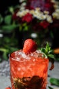 Strawberry Mojito. Cold summer mojito cocktail with strawberries, mint, lemon and ice in a glass on a table. on a dark background Royalty Free Stock Photo