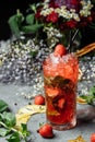 Strawberry Mojito. Cold summer mojito cocktail with strawberries, mint, lemon and ice in a glass on a table. on a dark background Royalty Free Stock Photo