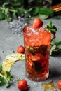 Strawberry Mojito. Cold summer mojito cocktail with strawberries, mint, lemon and ice in a glass on a table. on a dark background Royalty Free Stock Photo