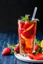 Strawberry Mojito. Cold summer mojito cocktail with strawberries, mint, lemon and ice in a glass on a blue wooden table. on a dark Royalty Free Stock Photo