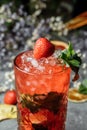 Strawberry Mojito. Cold summer mojito cocktail with strawberries, mint, lemon and ice in a glass on a table. on a dark background Royalty Free Stock Photo