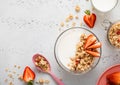 Strawberry organic granola with milk and pink spoon on light kitchen board Royalty Free Stock Photo