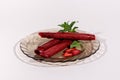 Strawberry pastille rolls and strawberry slice on a plate decorated with fresh mint isolated on white background. Healthy Eating.