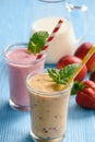 Strawberry and peach milkshakes on blue background. Royalty Free Stock Photo