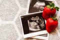 Strawberry and photos of a human fetus from ultrasound scan during pregnancy on right side gray background