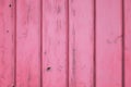 Strawberry pink pastel color background of aged wood with vertical planks.
