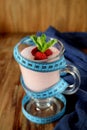 Strawberry protein cocktail decorated with berries and mint in an Irish mug wrapped into a blue measure tape. Royalty Free Stock Photo