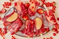 Strawberry raspberry apple and red currant ice cream popsicles in metal tray with ice cubes