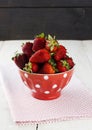 Strawberry in red bowl with a pattern in peas on fabric napkin o Royalty Free Stock Photo