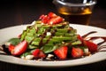 Strawberry salad with spinach, feta cheese, avocado, balsamic vinegar and olive oil in a plate