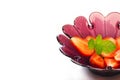 Strawberry slice and mint in purple flower shape bowl on white background Royalty Free Stock Photo