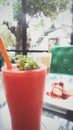 Strawberry smoothie on background is green sofa