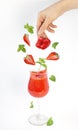 Strawberry smoothie and falling pieces of berries and sprigs of mint in a glass.Levitation ,Isolated objects on white background.