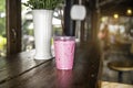 Strawberry smoothie, frappuccino, latte or milkshake in take away at cafe on wooden table