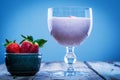 Strawberry smoothie in a glass with fresh strawberries in a bowl aside Royalty Free Stock Photo