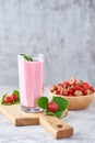 Strawberry smoothie in glass jar and fresh strawberries in wooden bowl on a cutting board Royalty Free Stock Photo