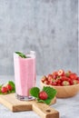 Strawberry smoothie in glass jar and fresh strawberries in wooden bowl on a cutting board Royalty Free Stock Photo