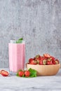 Strawberry smoothie in glass jar and fresh strawberries in wooden bowl on a gray background. Healthy breakfast Royalty Free Stock Photo