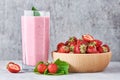 Strawberry smoothie in glass jar and fresh strawberries in wooden bowl on a gray background. Healthy breakfast Royalty Free Stock Photo