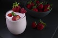 Strawberry smoothie / milkshake glass with fresh strawberries in a bowl,dark food Royalty Free Stock Photo