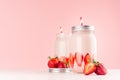 Strawberry smoothie in retro glass jar with bright sliced berries, straw and silver lid on light, soft, pink background. Royalty Free Stock Photo