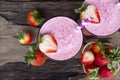 Strawberry smoothies and strawberry fruit for for milkshake on wooden background from the top view. Royalty Free Stock Photo
