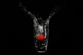 Strawberry splash inside a glass of water - black background - high speed photography Royalty Free Stock Photo