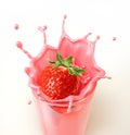 Strawberry splashing into a glass full of milkshake.