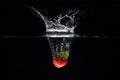 A strawberry splashing into water