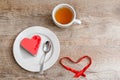 Strawberry sweet heart shaped cake on Valentines Day on plate with cup of tea with copy space on wooden table Royalty Free Stock Photo