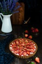Strawberry tart on dark wooden table
