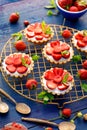 Strawberry tarts, small shortbread tarts with the addition of cream cheese, fresh strawberries on a cooling tray