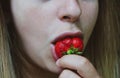 Strawberry. The taste of food. Happy girl tastes strawberries. Close up of female lips tasting strawberries. Sweet pleasure