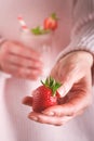 Strawberry. Woman holding fresh berry strawberry on the background of  glass vegan smoothie from strawberry, banana, chia seeds an Royalty Free Stock Photo