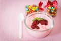 Strawberry yogurt with strawberry on Baby Gift Colorful candies in jar on table pink background. strawberry yoghurt. pink yogurt