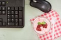 Strawberry yogurt on desk with mount keyboard