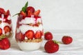 Strawberry yogurt parfait with granola, mint and fresh berries in glasses on white wooden table. Royalty Free Stock Photo