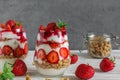 Strawberry yogurt parfait with granola, mint and fresh berries in glasses on white wooden table. healthy breakfast