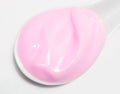 Strawberry yogurt, pink cream, in spoon, white background