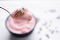 Strawberry yogurt with sunflower seeds on spoon with strawberry yogurt