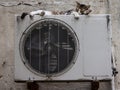 Stray cat in a street sleeping on the condenser unit of an AC air conditioning system