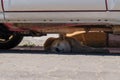 Stray dog is sleeping in the hot summer day under the car Royalty Free Stock Photo