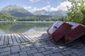 Strbske pleso, High Tatras mountains, Slovakia, early summer morning, lake reflections, red boats on wooden pier Royalty Free Stock Photo