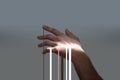 Streaks of light trickle down of soft female hand on grey background.