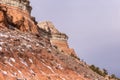 Streaks of snow along red rock mountain face on clear day